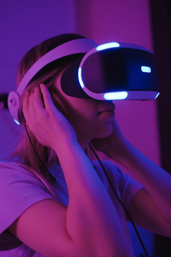 Woman enjoying a virtual reality experience wearing neon-lit VR goggles.